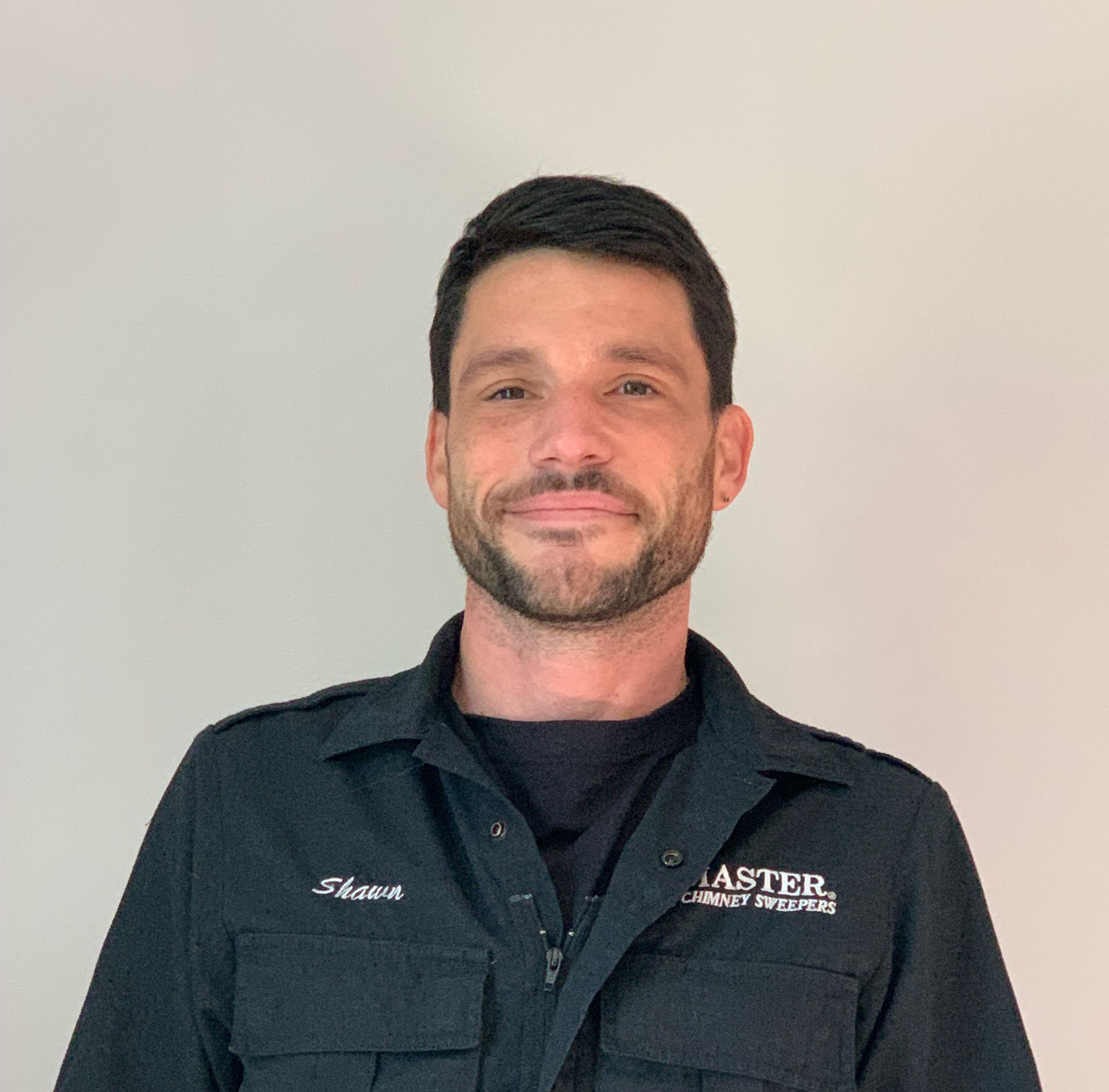 A man with a beard is wearing a black shirt that says master on it.