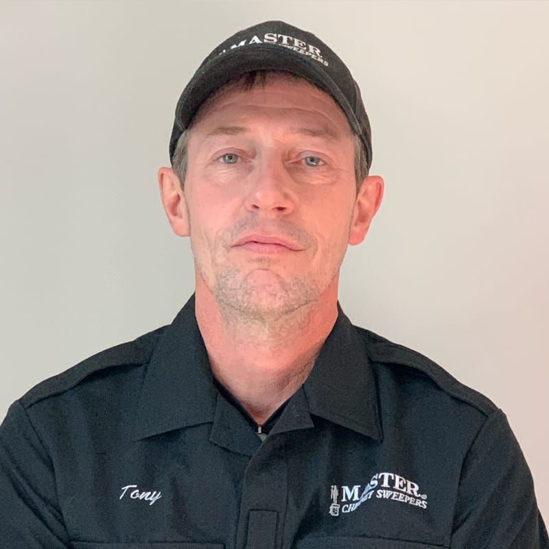 A man wearing a hat and a black shirt with the name tony on it.