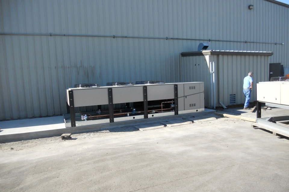 Outdoor equipment against a building; a person walks near the structures.