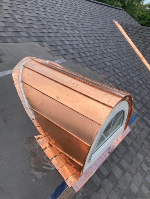 A copper roof with a lightning rod attached to it