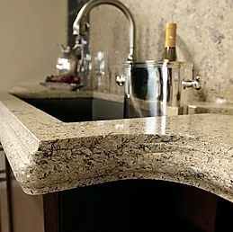 A kitchen sink with a granite counter top and a faucet.