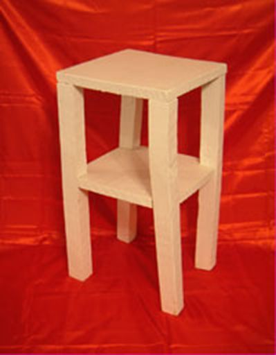 A small white table with a shelf sits on a red cloth