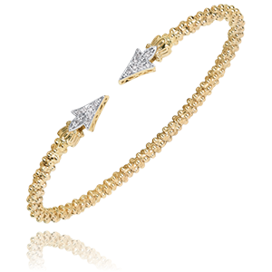 A gold bracelet with a diamond arrow on it