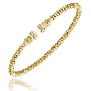 A yellow gold bracelet with diamonds on a white background