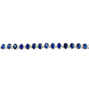 A sapphire and diamond tennis bracelet in white gold on a white background.