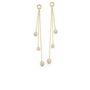 A pair of gold dangle earrings with pearls on a white background.