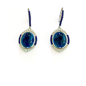 A pair of earrings with blue stones on a white background