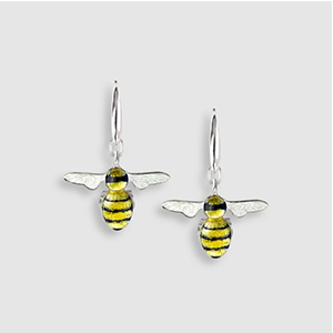 A pair of yellow and black bee earrings on a white surface.