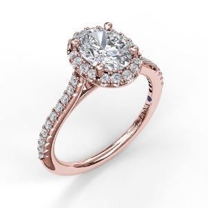 A rose gold engagement ring with an oval diamond in the center surrounded by smaller diamonds.