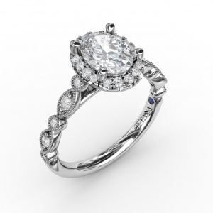 A white gold ring with an oval diamond in the center surrounded by smaller diamonds.