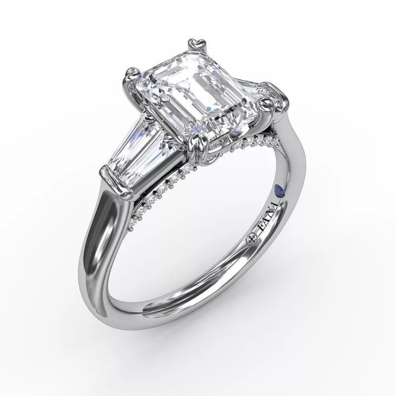 A white gold ring with an emerald cut diamond in the center
