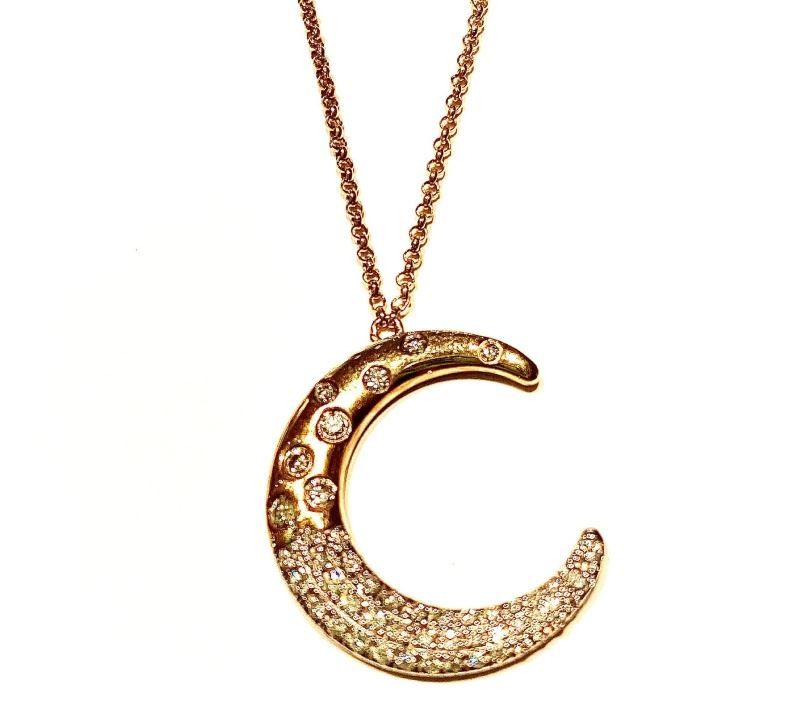 A gold necklace with a crescent moon shaped pendant