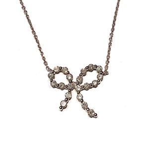 A necklace with a bow shaped pendant on a chain