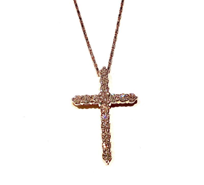 A necklace with a cross shaped pendant on a chain