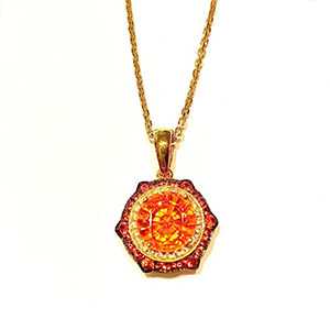 A necklace with an orange pendant on a gold chain