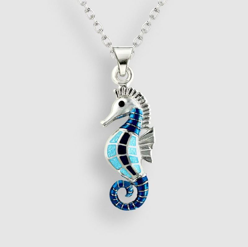 A necklace with a blue seahorse pendant on a chain