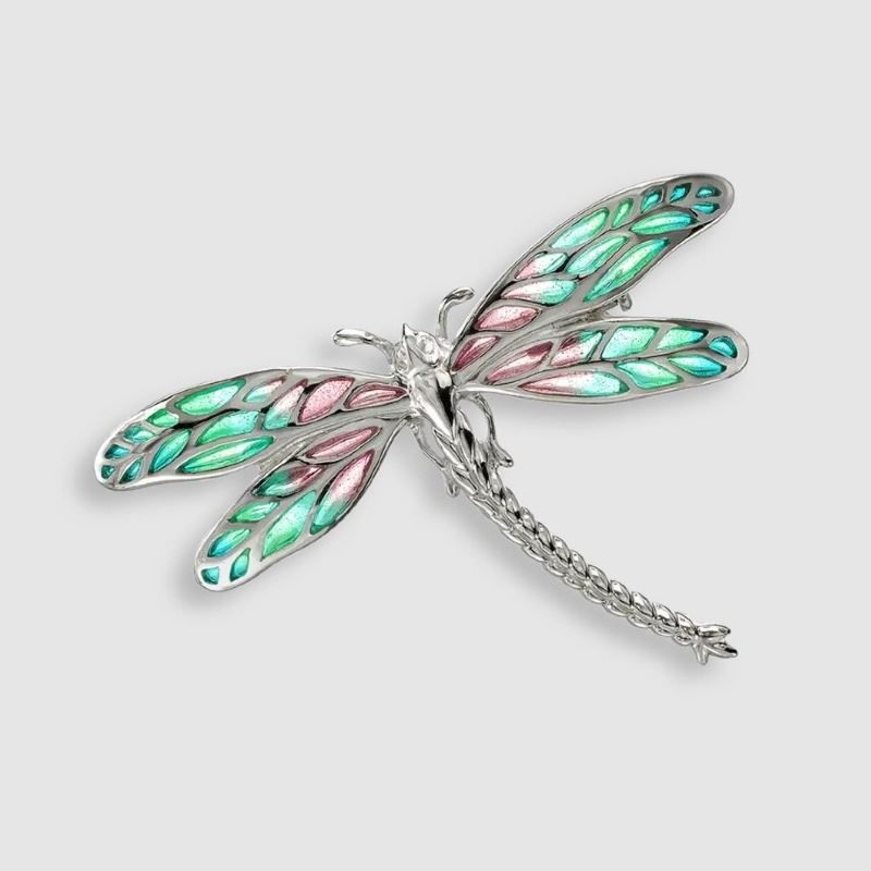 A brooch in the shape of a dragonfly with green and pink wings