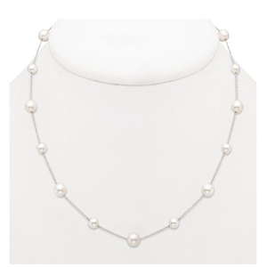 A white pearl necklace is on a white mannequin.