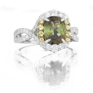 A ring with a green stone and yellow diamonds on a white surface.