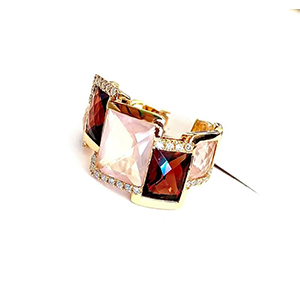 A gold ring with square stones and rhinestones on a white background