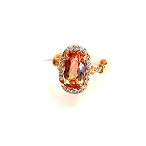 A gold ring with an orange stone and diamonds on a white background.
