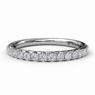 A white gold wedding band with diamonds on a white background.