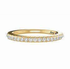 A yellow gold wedding band with diamonds on a white background.