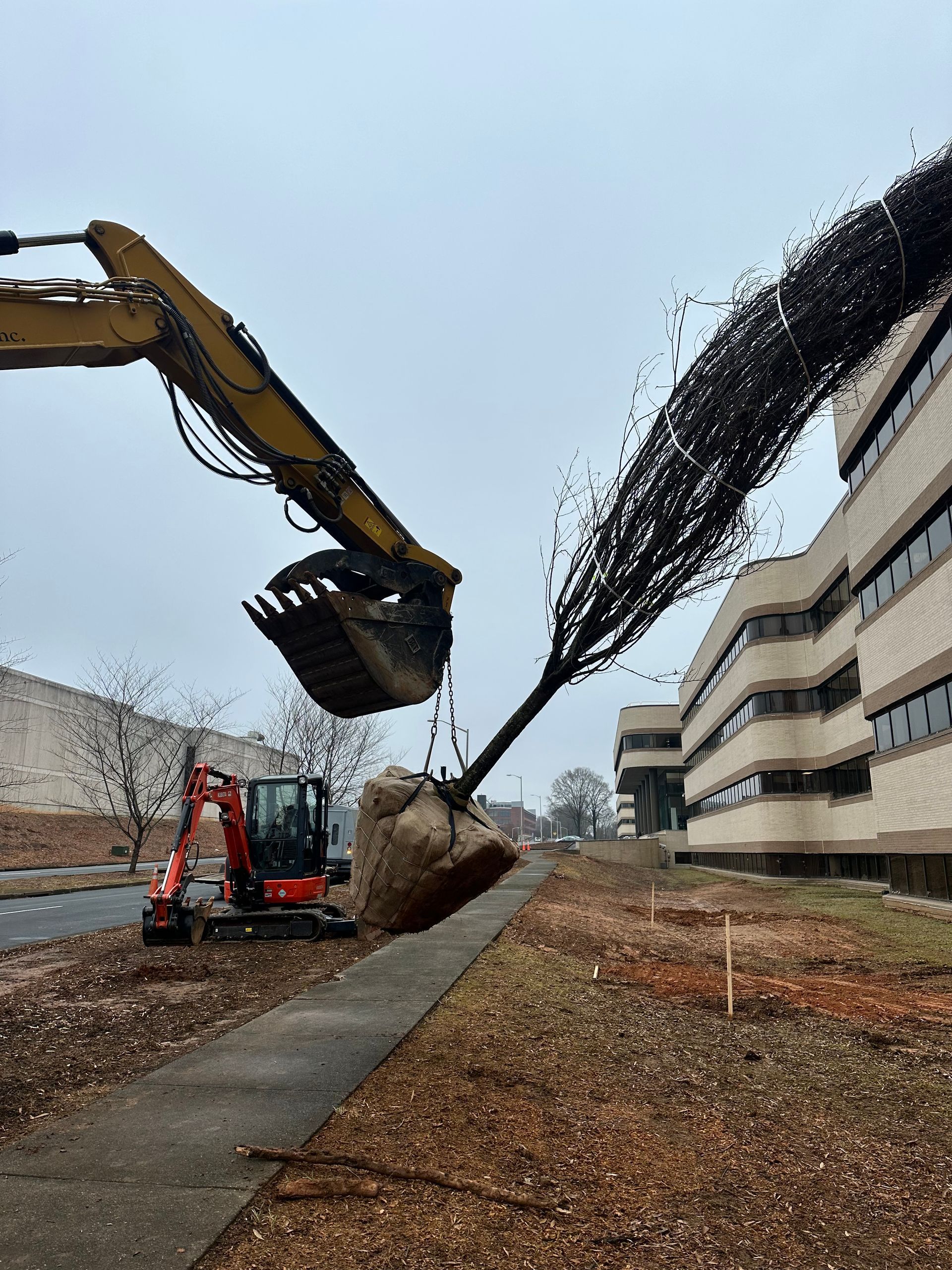A bulldozer is digging a hole in the ground in front of a building.