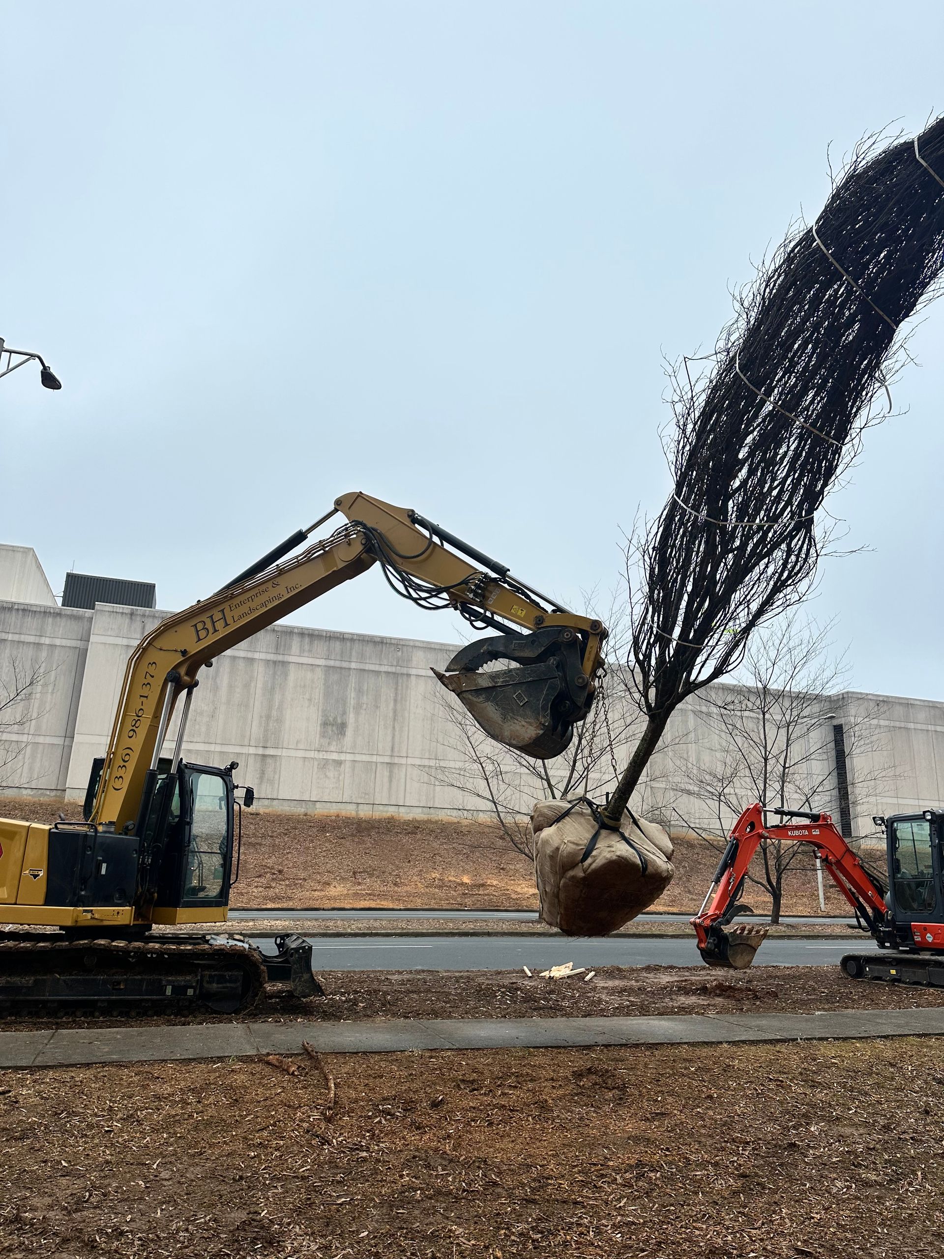 A couple of excavators are working on a construction site.