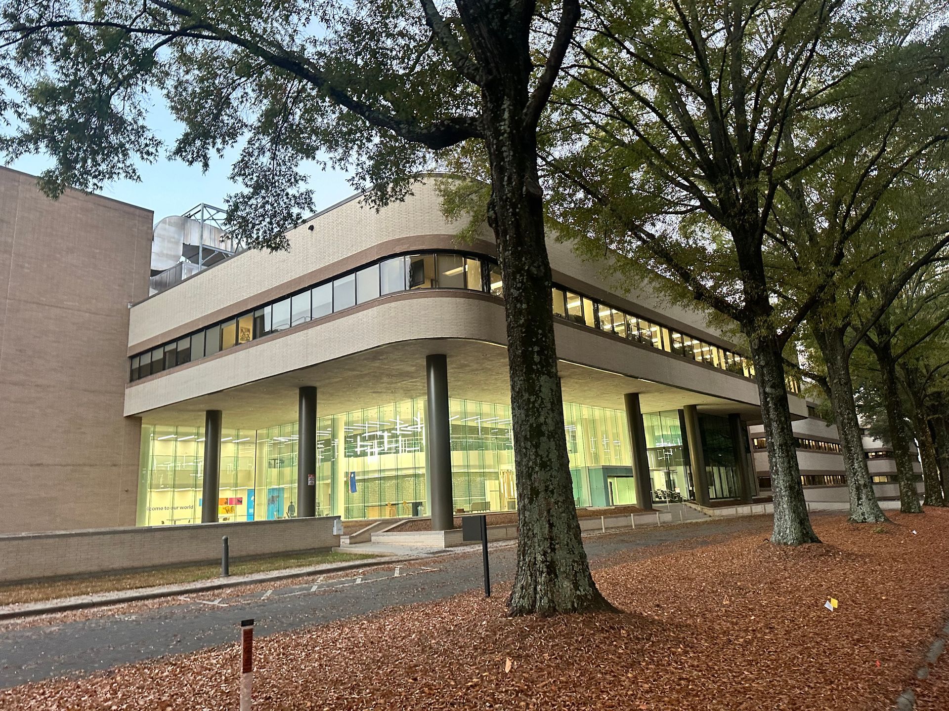 A large building with a lot of windows and trees in front of it