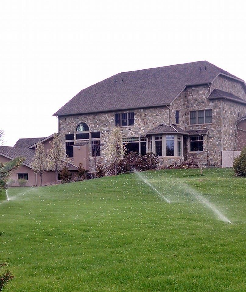 A large house with a sprinkler in front of it