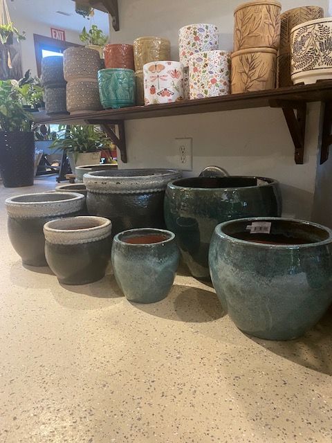 a bunch of pots are sitting on a counter next to a shelf