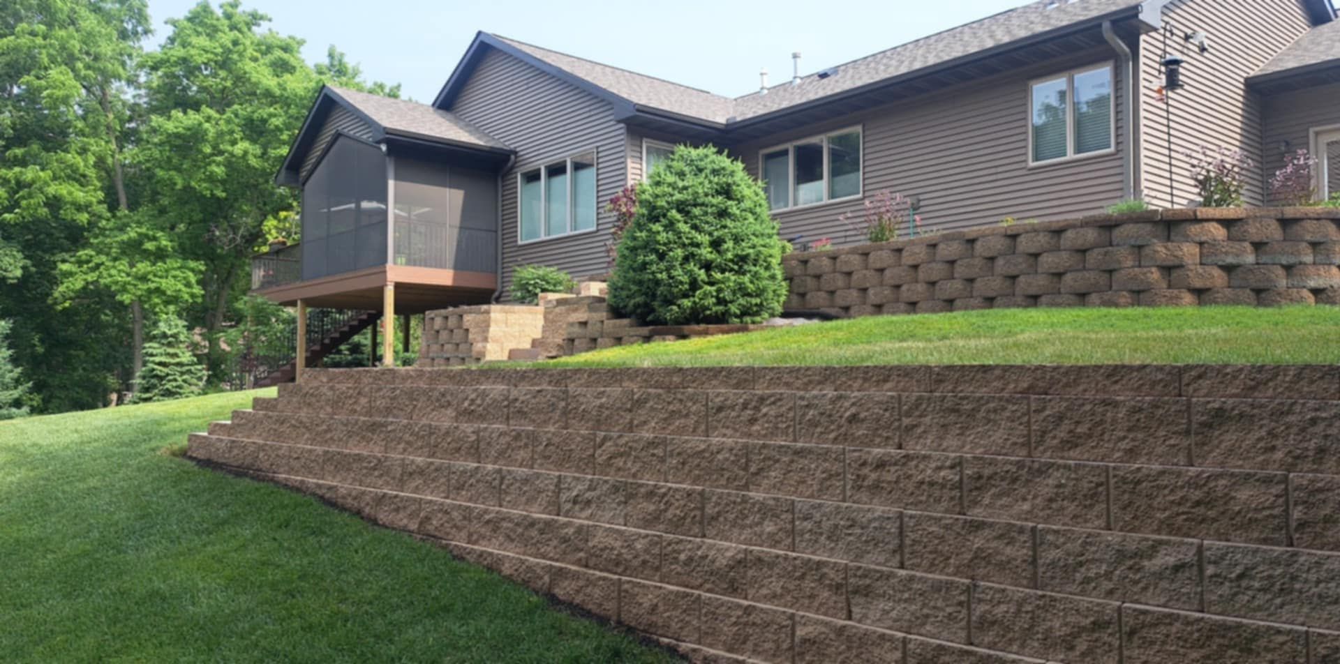 A large house with a retaining wall in front of it