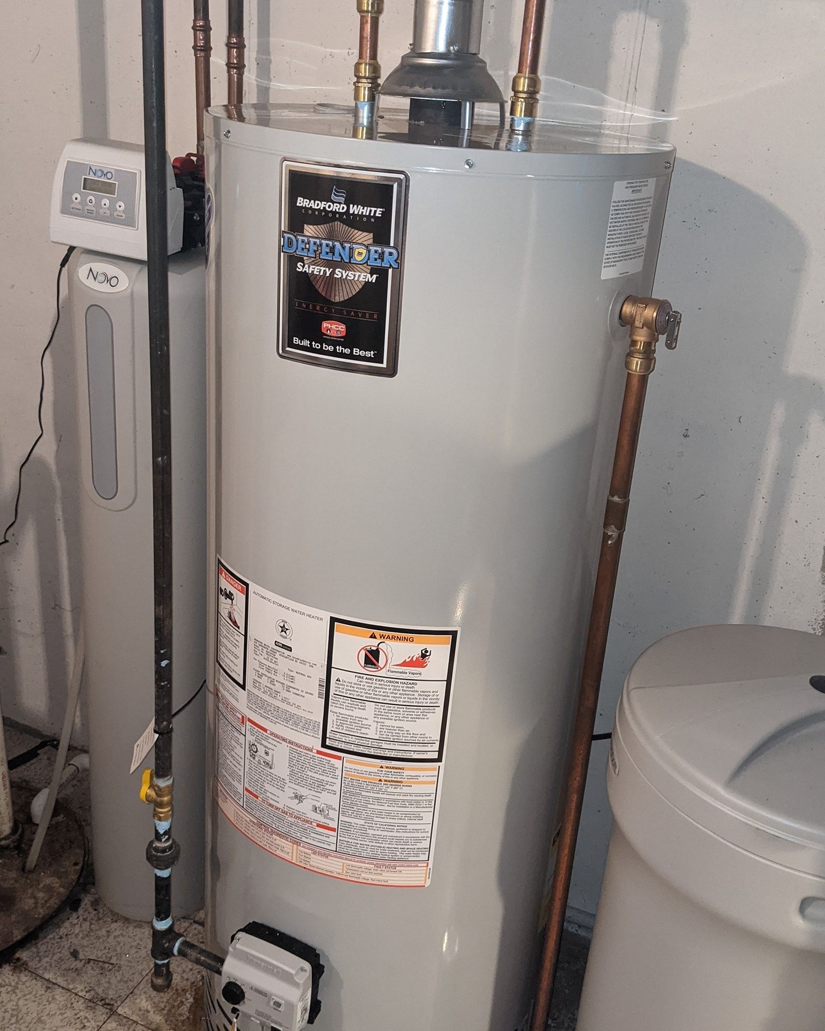 A water heater and water softener in a basement setting.