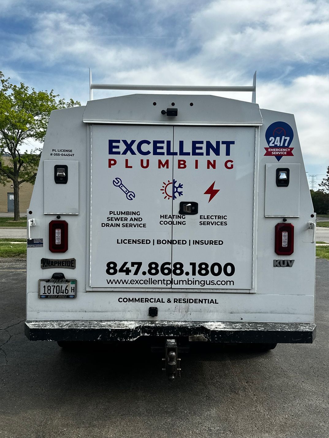 White plumbing truck with Excellent Plumbing logo, contact info, and service icons against a cloudy sky.