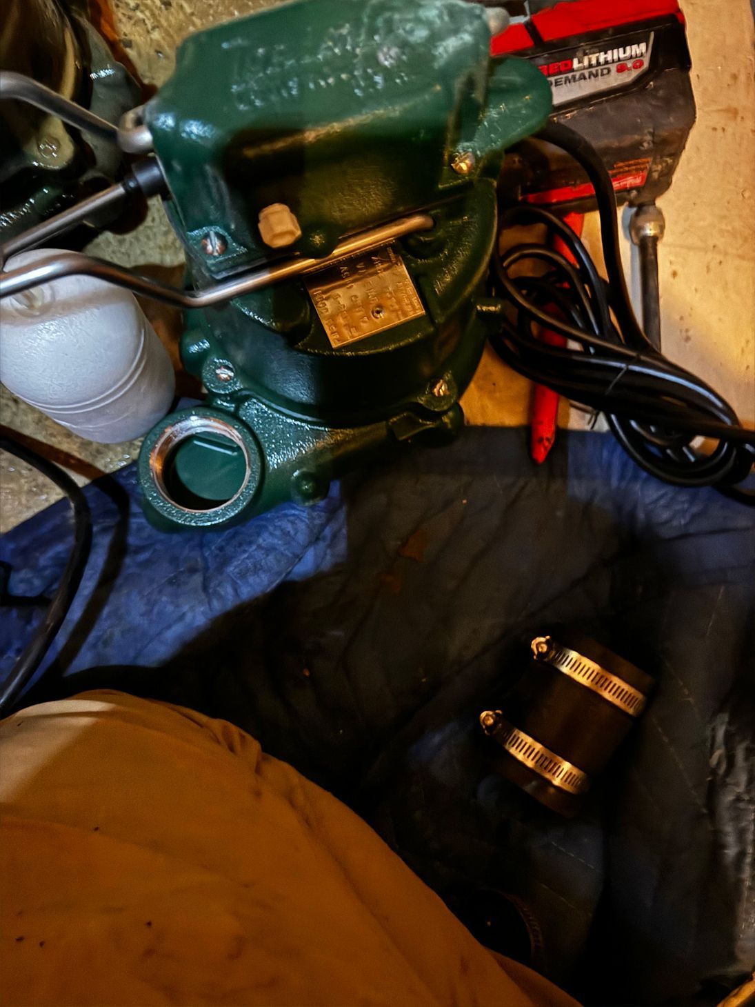 Green vise with label, black clamps, and electrical cord on a blue cloth.
