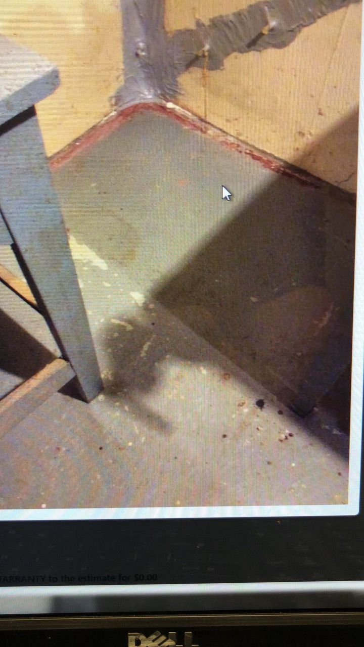 A gray concrete floor with a shadow cast from a wooden table leg.