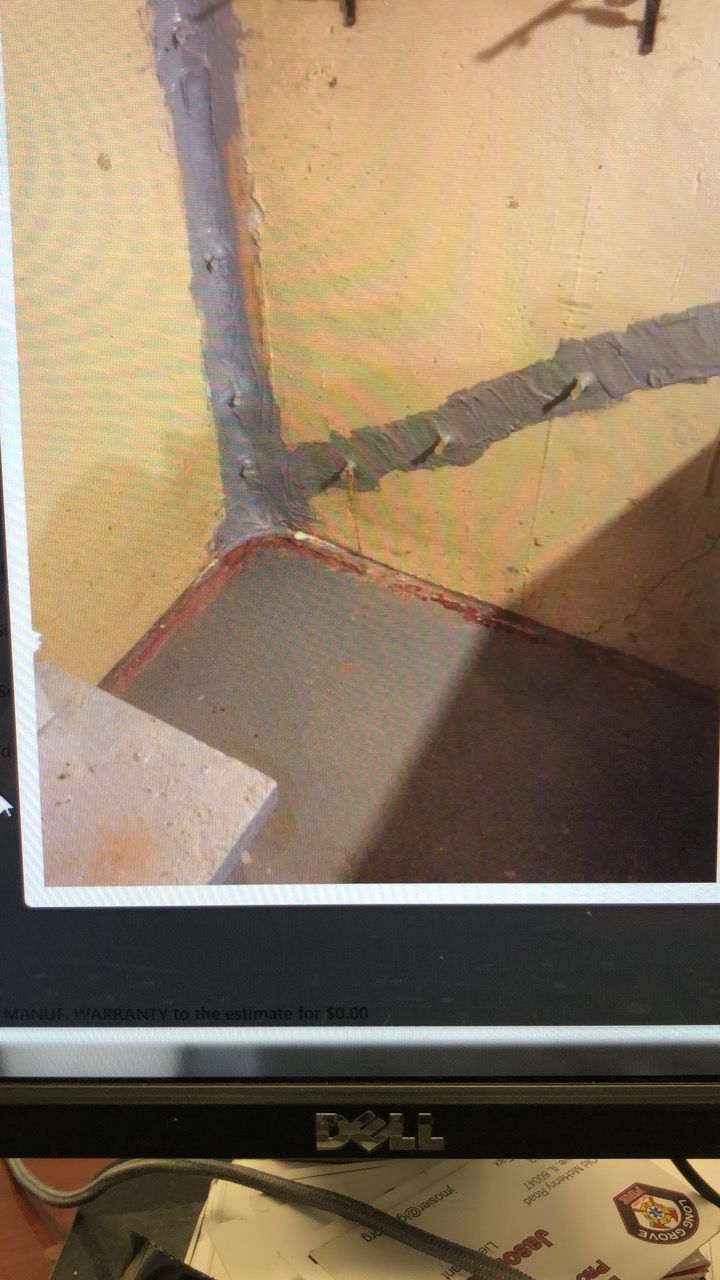 Gray sealant along edges of tan and brown surfaces, possibly a corner.