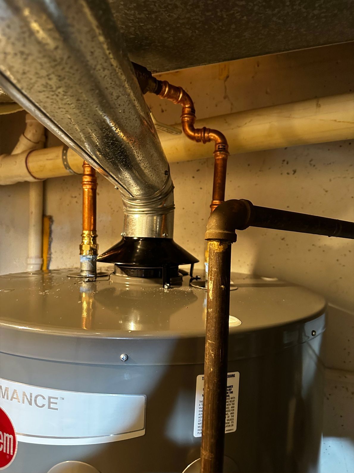 Water heater with copper pipes connected to a vent.
