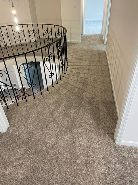 A staircase with a wrought iron railing and a carpeted floor.