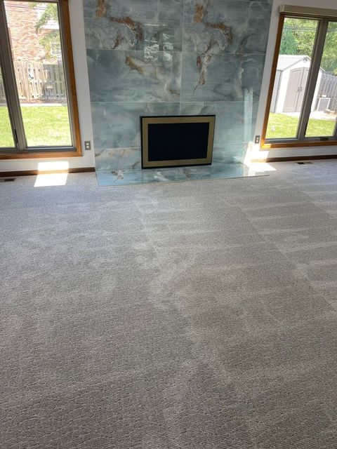 A living room with a fireplace and a carpeted floor.
