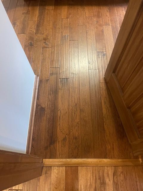 A wooden floor next to a door in a room.