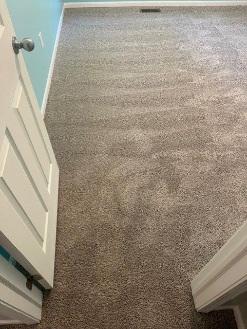 A room with a carpeted floor and a door leading to it.