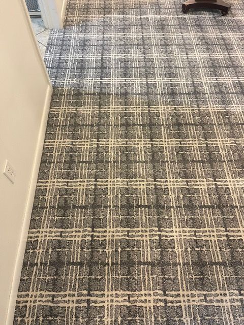 A carpeted floor with a checkered pattern in a room.