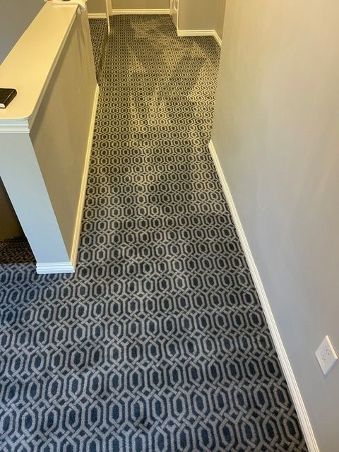 A hallway with a patterned carpet on the floor