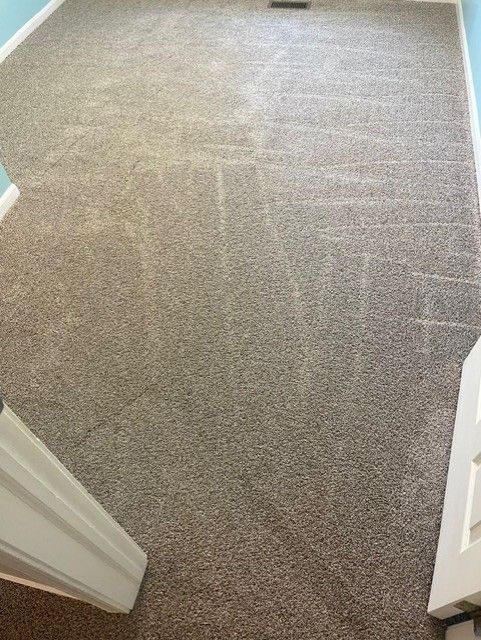 A room with a carpeted floor and a door.