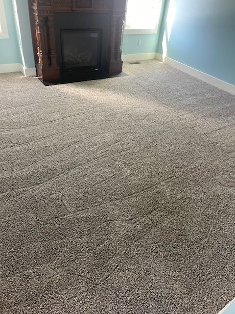 A living room with a fireplace and a carpeted floor.