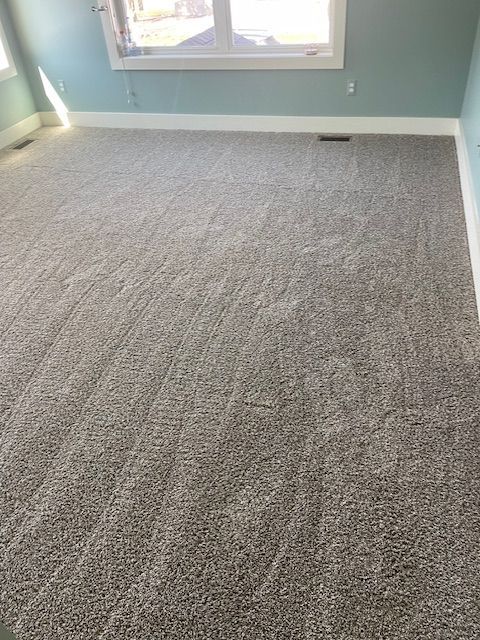 A room with a lot of carpet and a window.