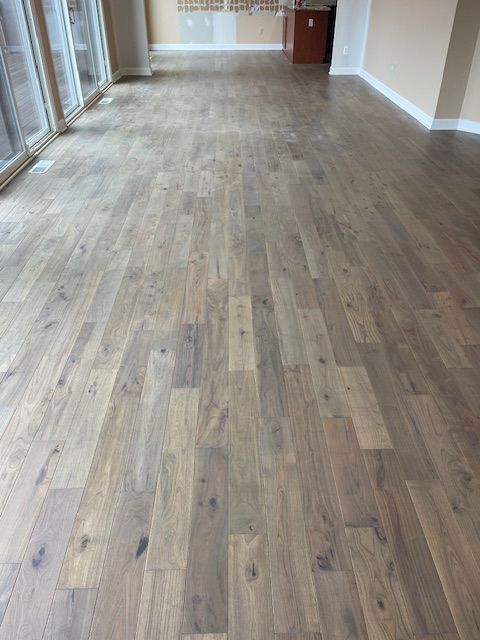 A living room with a wooden floor and a lot of windows.