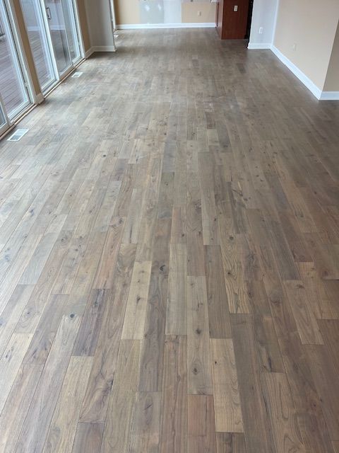 A large room with a wooden floor and lots of windows.